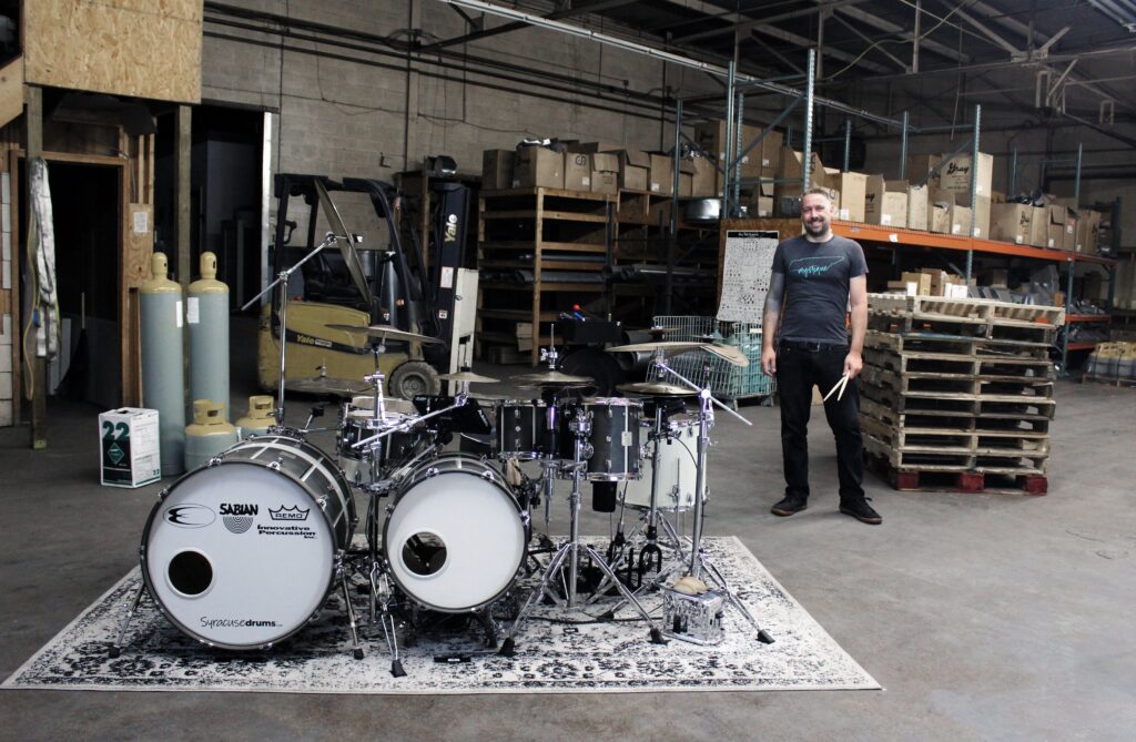 Time Machine drumset with Patrick Blakely standing to side