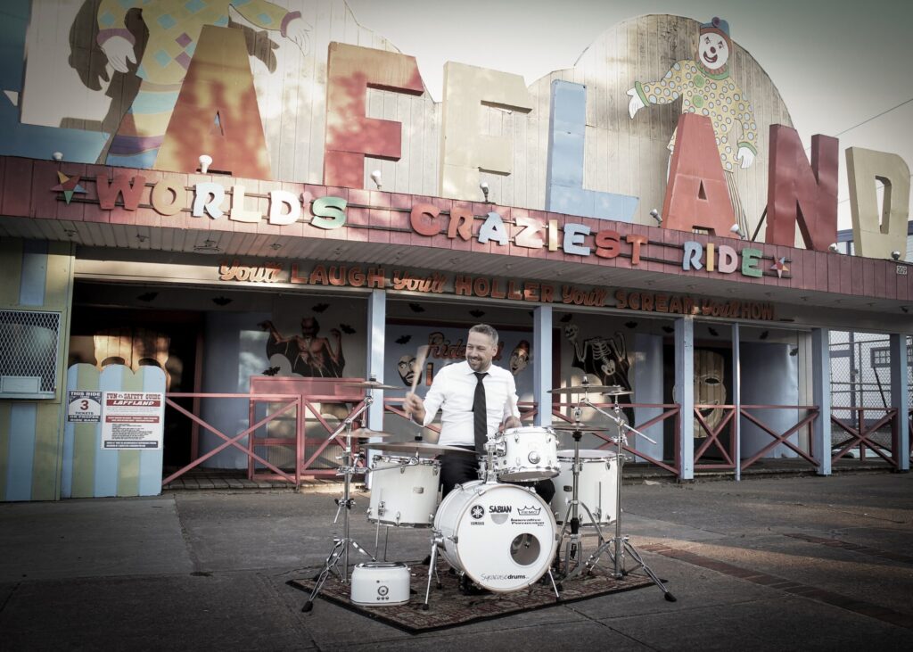 White Noise drum set in front of Laffland at Sylvan Beach